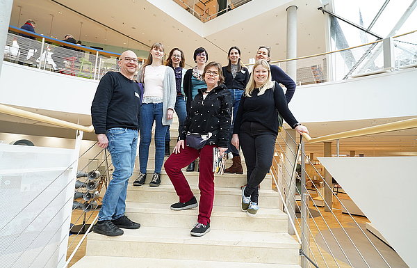 kleine Gruppe steht auf einer Treppe in großem Gebäude