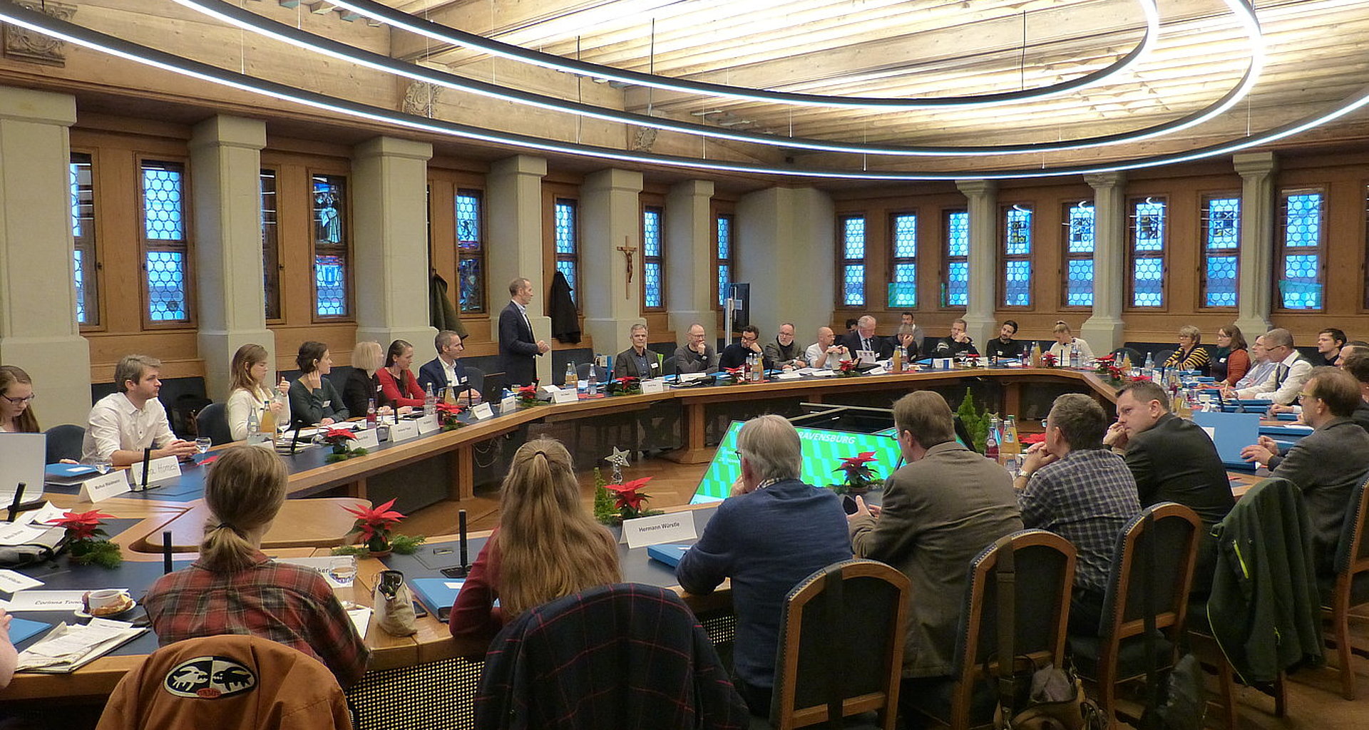 Bild der Ravensburger Klimakommision. Ein runder Kreis aus Tischen an denen viele junge und alte Menschen sitzen.