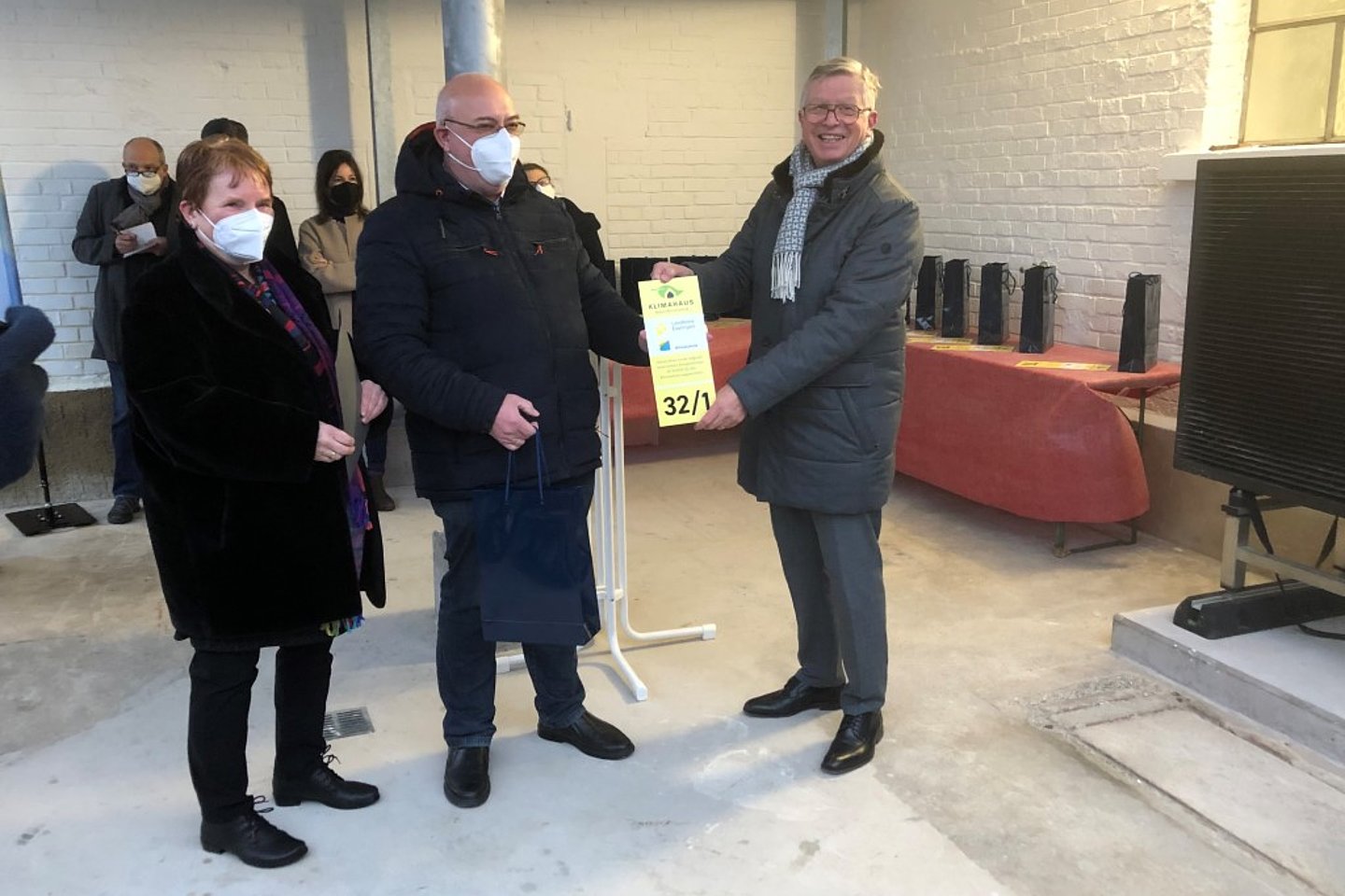 Landrat Heinz Eininger überreicht zwei Hauseigentümern das Gütesiegel "Klimahaus" mit individuell gestaltetem Hausnummernschild