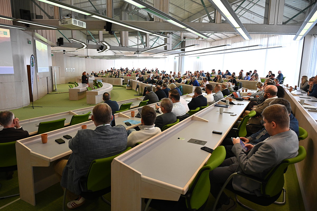in einem großen Raum mit Tischen beraten sich etwa 150 Personen