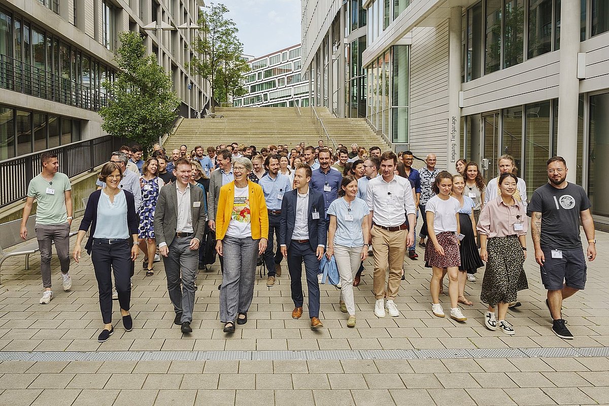 Alle Teilnehmenden der Vernetzungsveranstaltung 2024 sind auf dem Weg vom Ort des Gruppenbildes in die Veranstaltungsräume