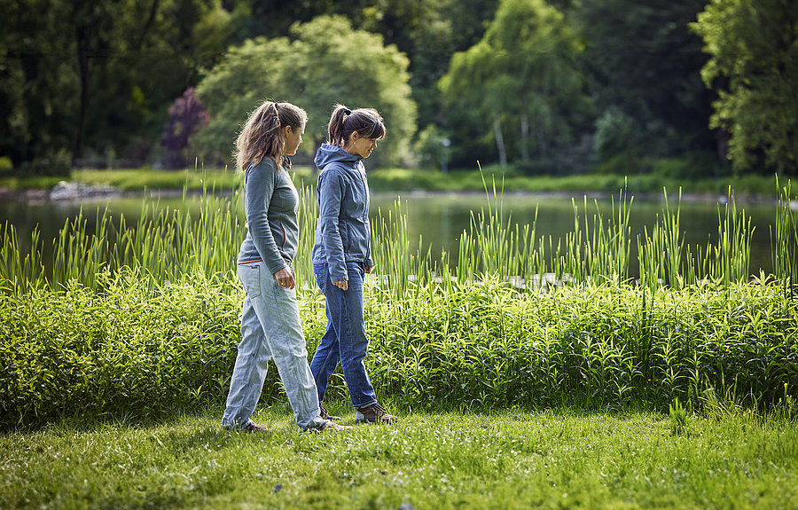 Zwei Frauen gehen an einem See spazieren