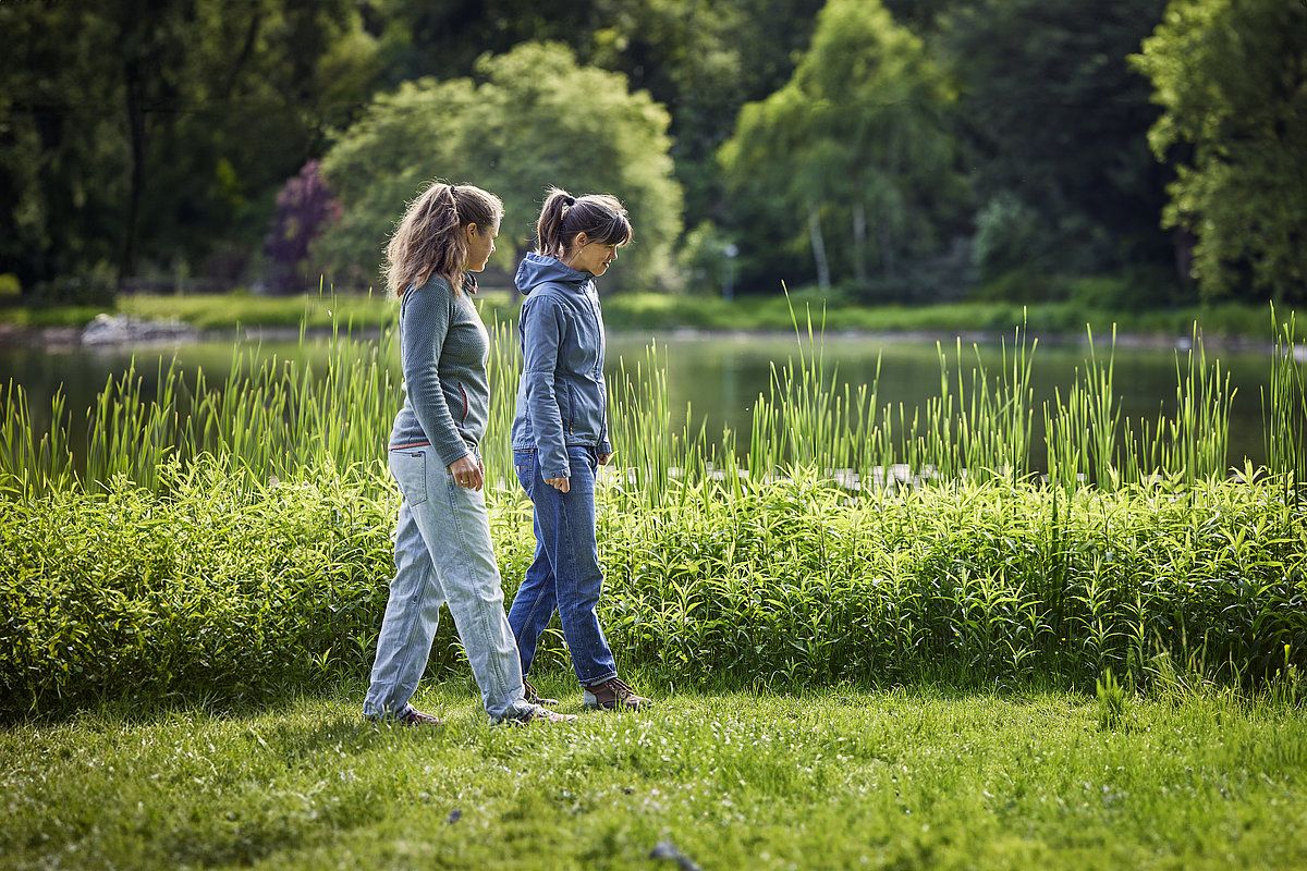 Zwei Frauen gehen an einem See spazieren