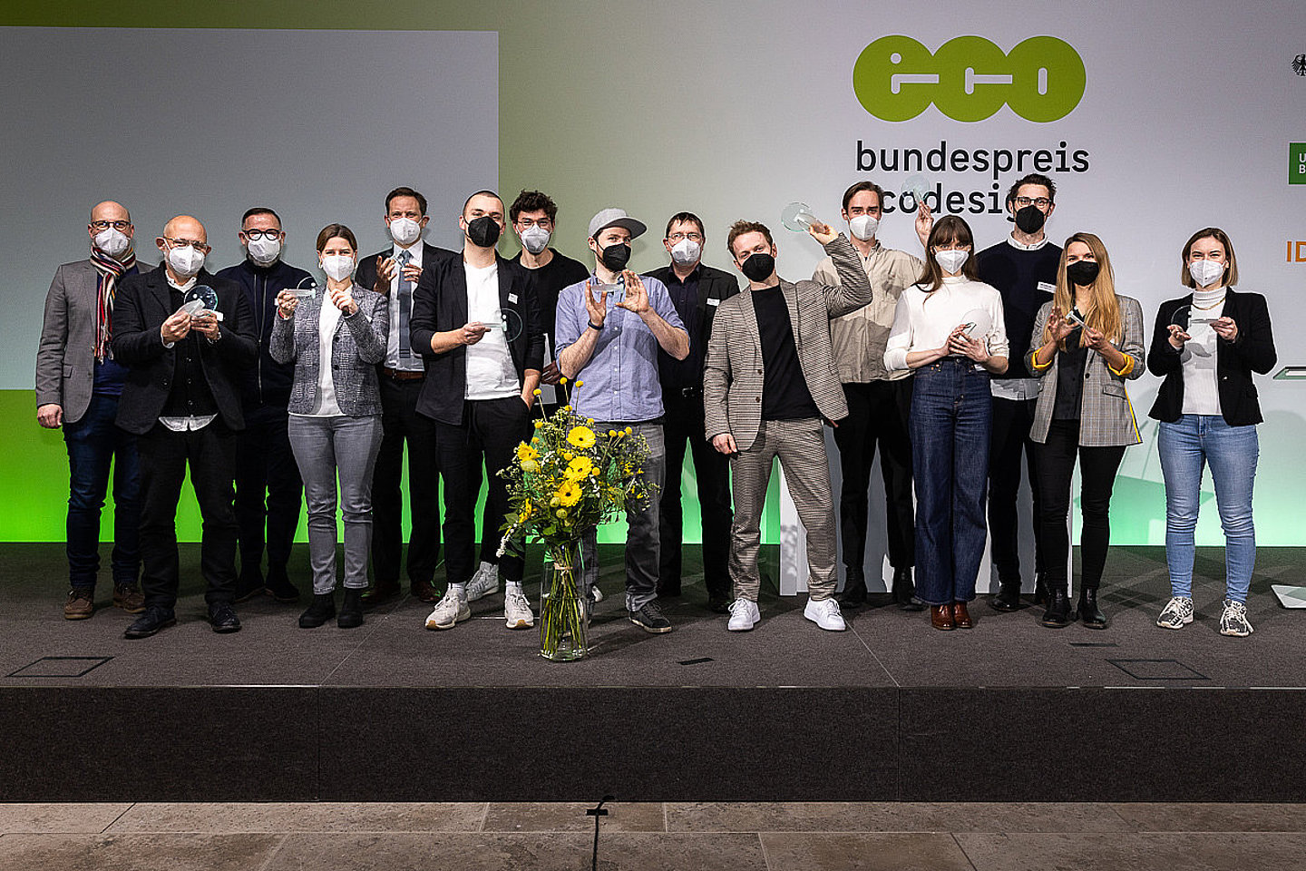 Foto der Preisträgerinnen und Preisträger des Bundespreises Ecodesign 2021, Alle Siegerinnen und Sieger stehen auf der Bühne mit einem Preis in der Hand