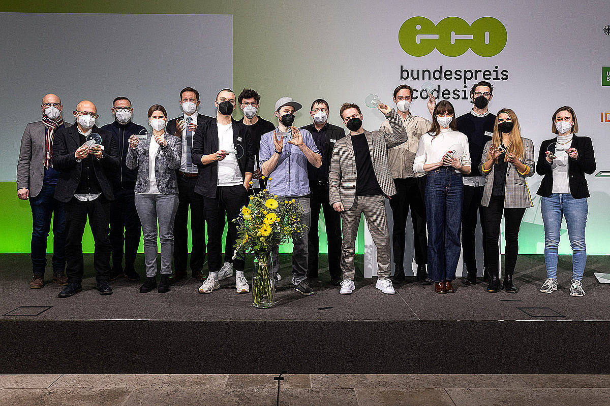 Foto der Preisträgerinnen und Preisträger des Bundespreises Ecodesign 2021, Alle Siegerinnen und Sieger stehen auf der Bühne mit einem Preis in der Hand