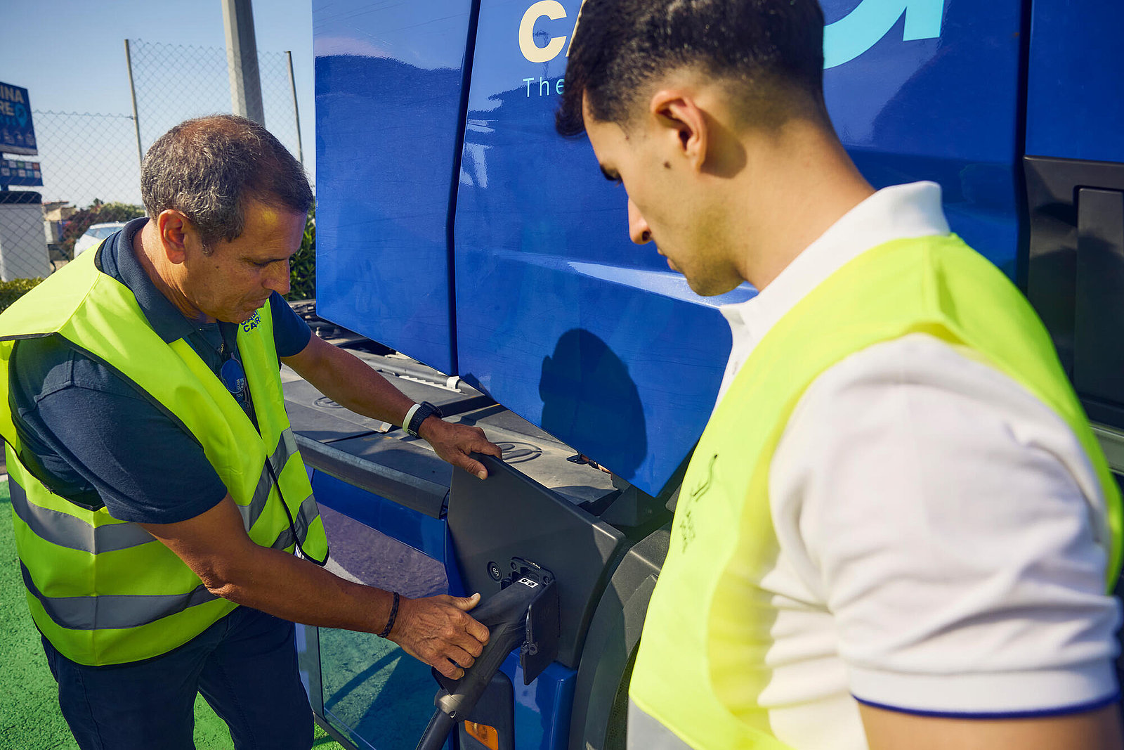 2 Mä#nner laden einen Elektr-Lkw