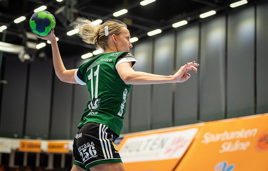 Frau in Turnhalle wirft Handball