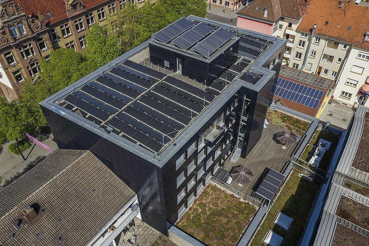 Großes Bürogebäude mit Photovoltaik auf dem Dach und and der Fassade.