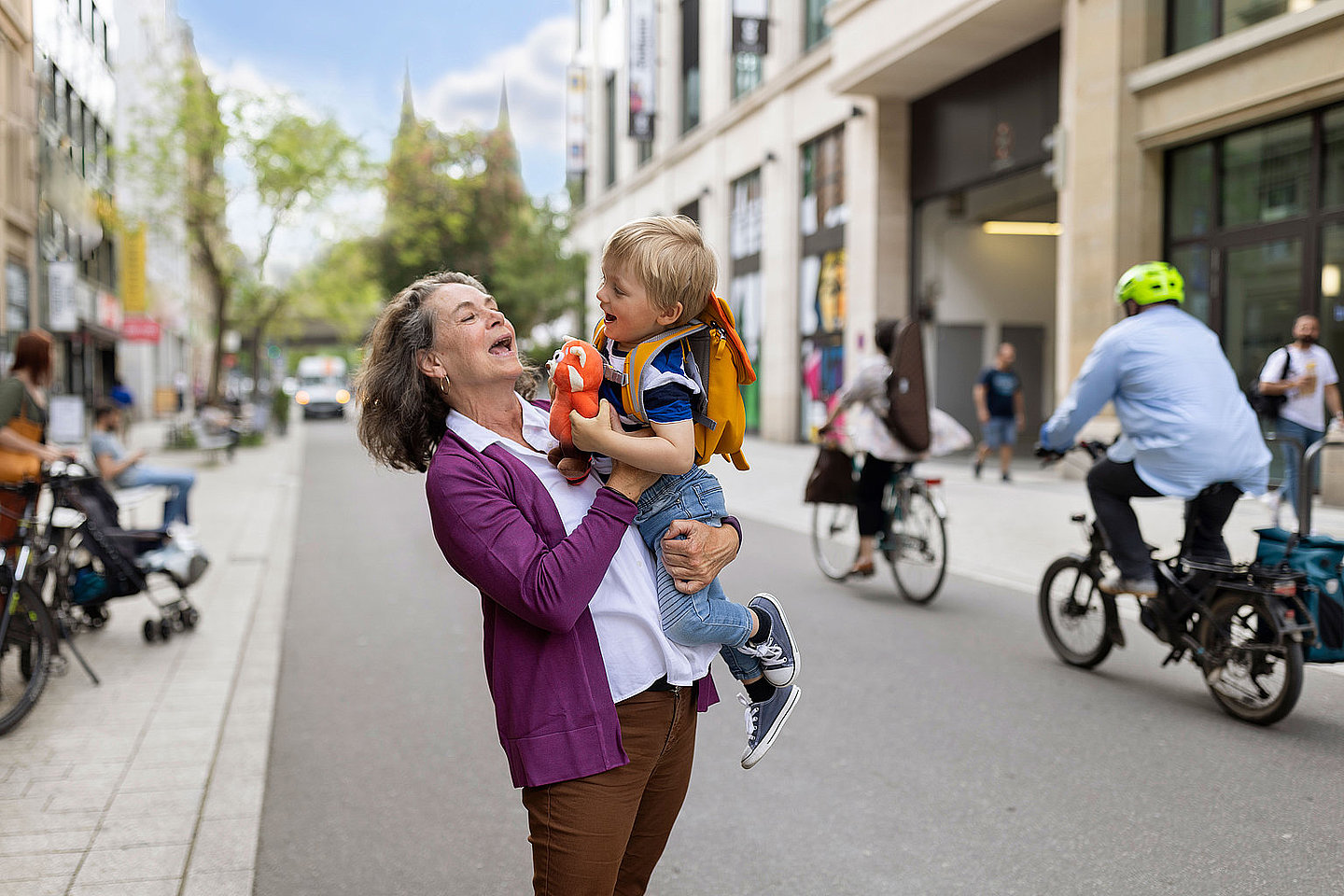 Seniorin mit Kind auf dem Arm in verkehrsberuhigter Innenstadt