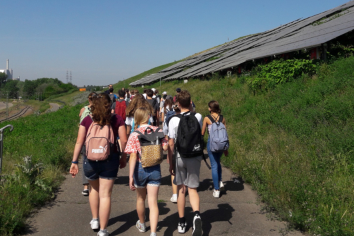 Gruppen von Schülern auf dem Weg zur solarthermischer Freiflächenanlage