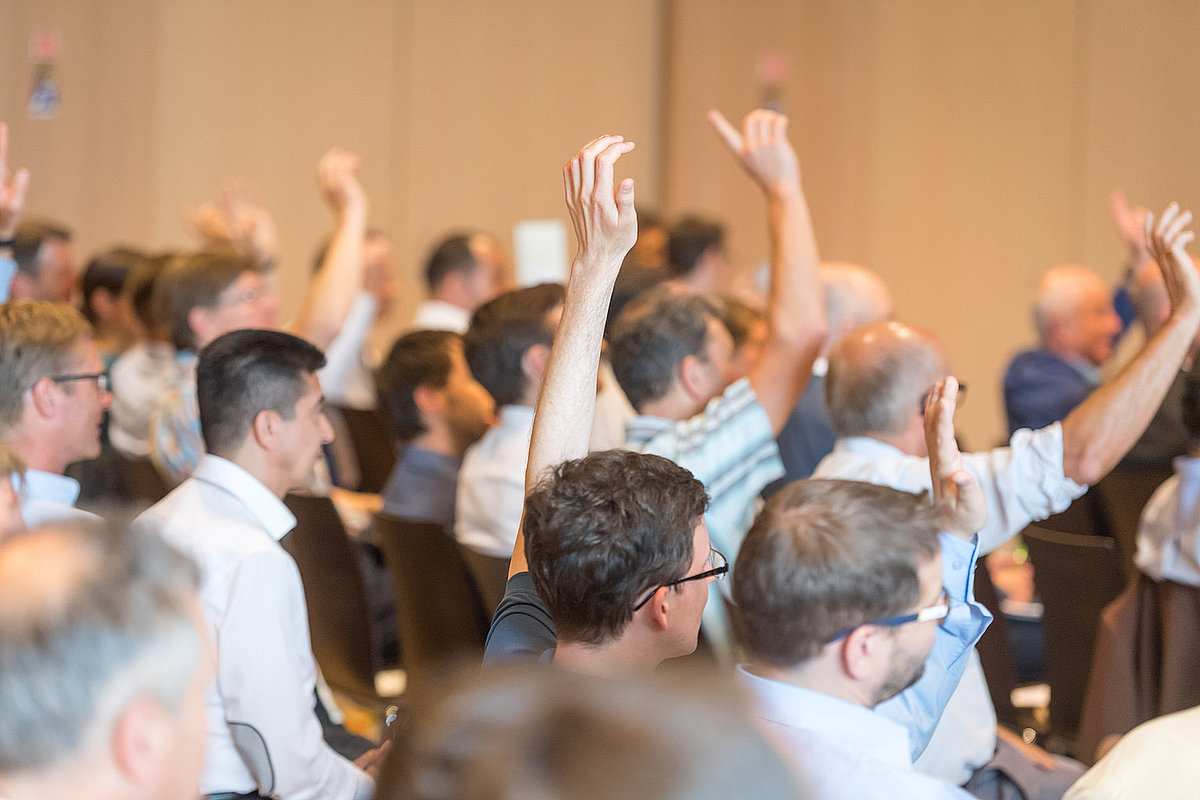 Menschen diskutieren in einem Saal