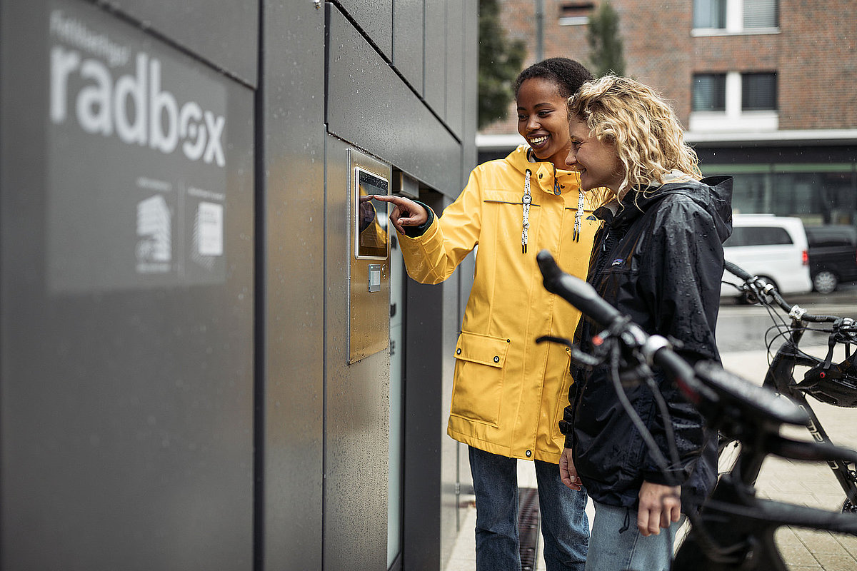 Zwei Frauen bei der Nutzung eines Fahrradparkhauses am Bahnhof