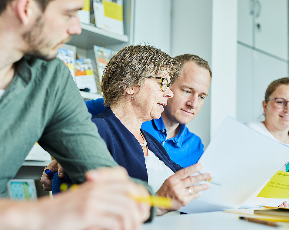 Vier Menschen besprechen sich und arbeiten zusammen