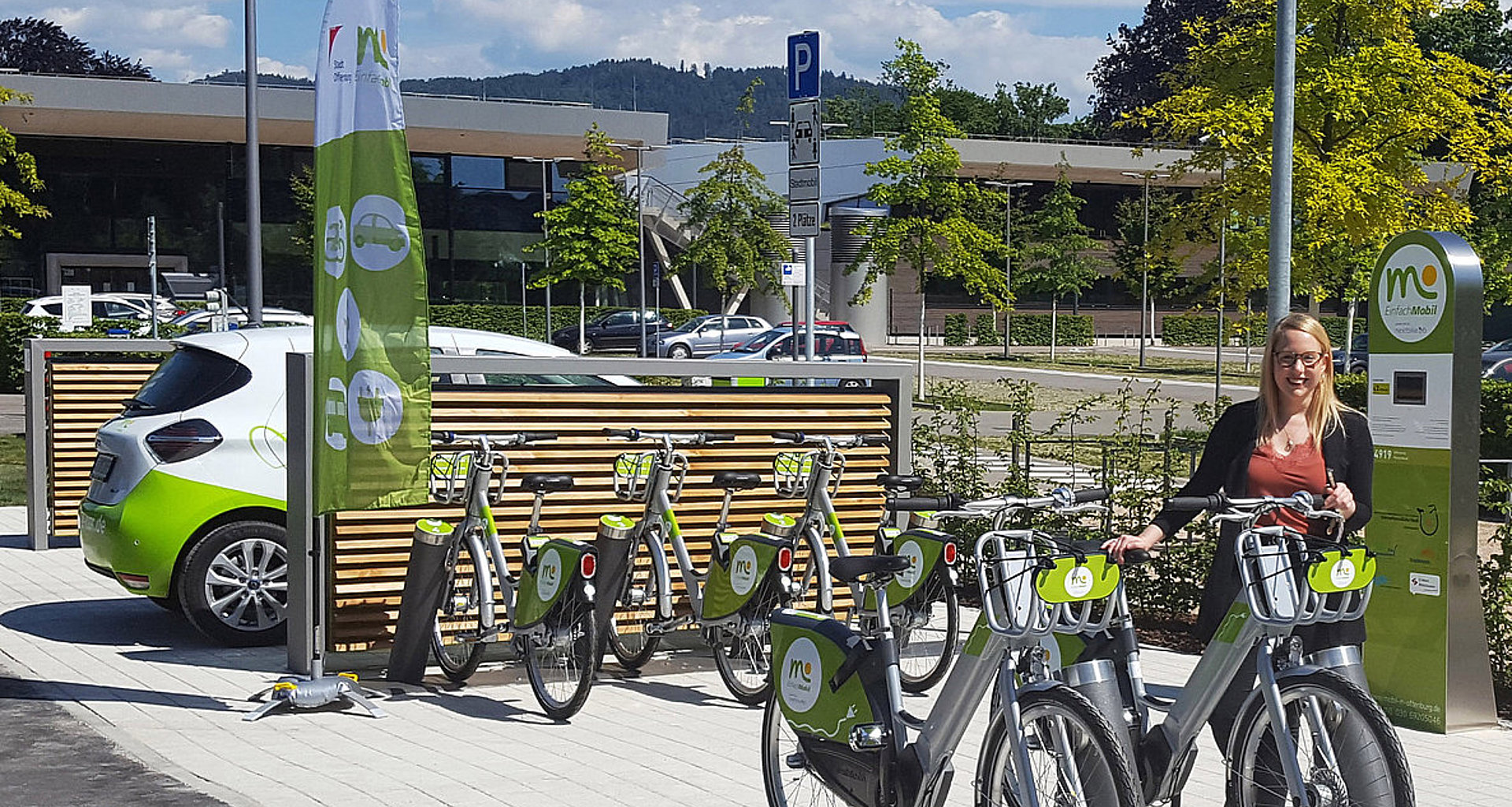 Foto zeigt eine Einfach Mobil Mibilitätsstation mit E-Bikes und einem Carsharing Auto.