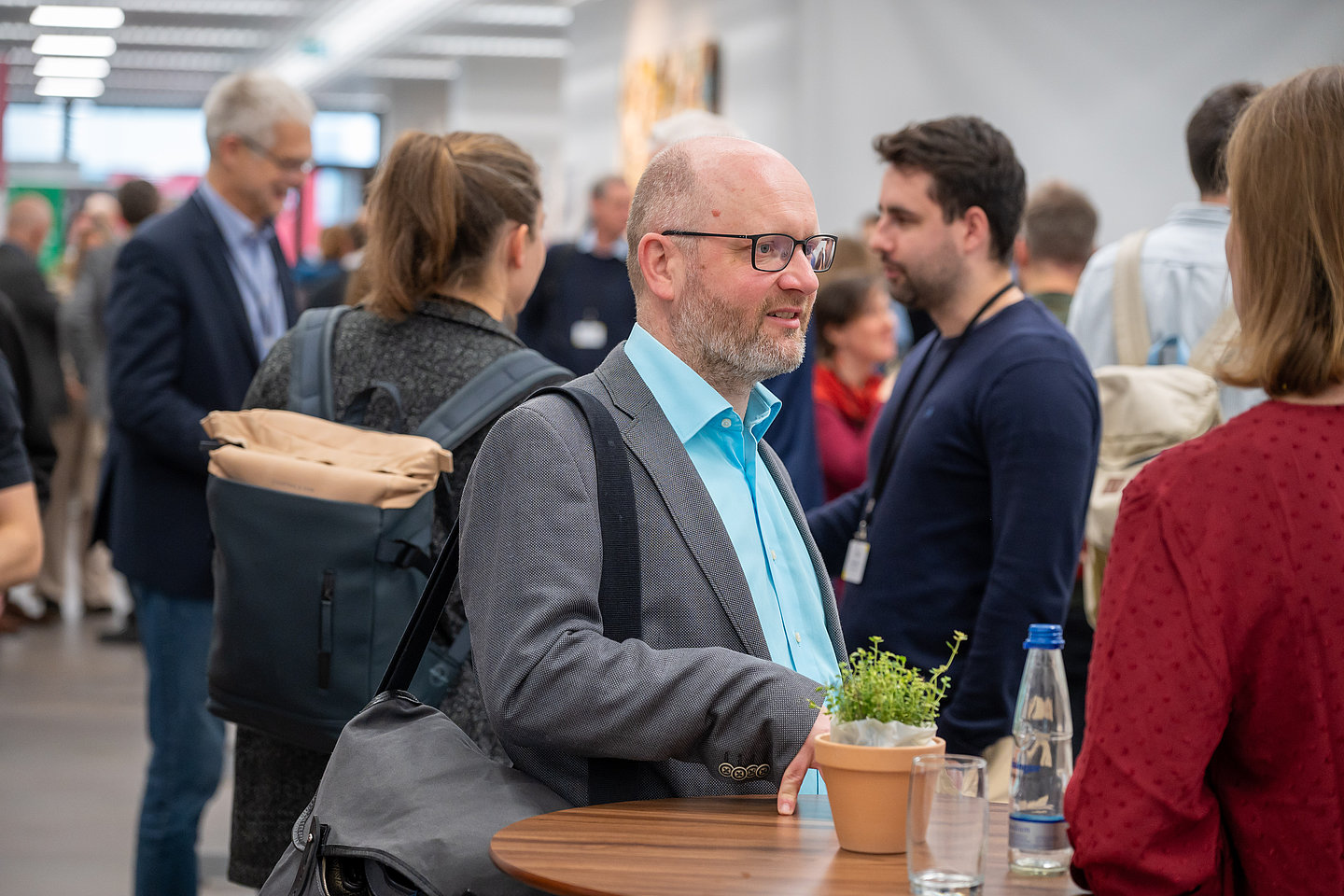 Menschen stehen in einem Foyer und unterhalten sich