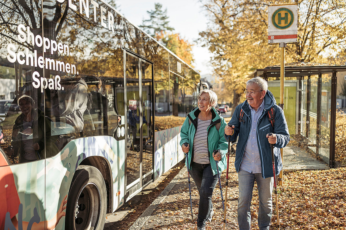 Zwei Menschen steigen in einen Bus ein