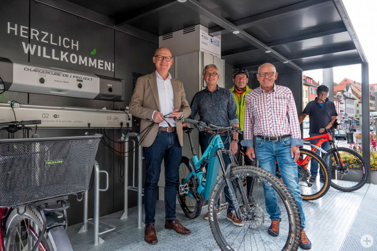 OB Ralf Broß, Rudolf Mager vom Fachbereich Bauen und Stadtentwicklung und der städtische Radbeauftragte Wilfried Geißler (vorne von links) präsentieren die neue E-Bike-Ladestation in der Innenstadt. Die Radler Willi Fischbach und Edy Käser (hinten von links) haben den Charger Cube bereits mit ihren E-Bikes getestet. 