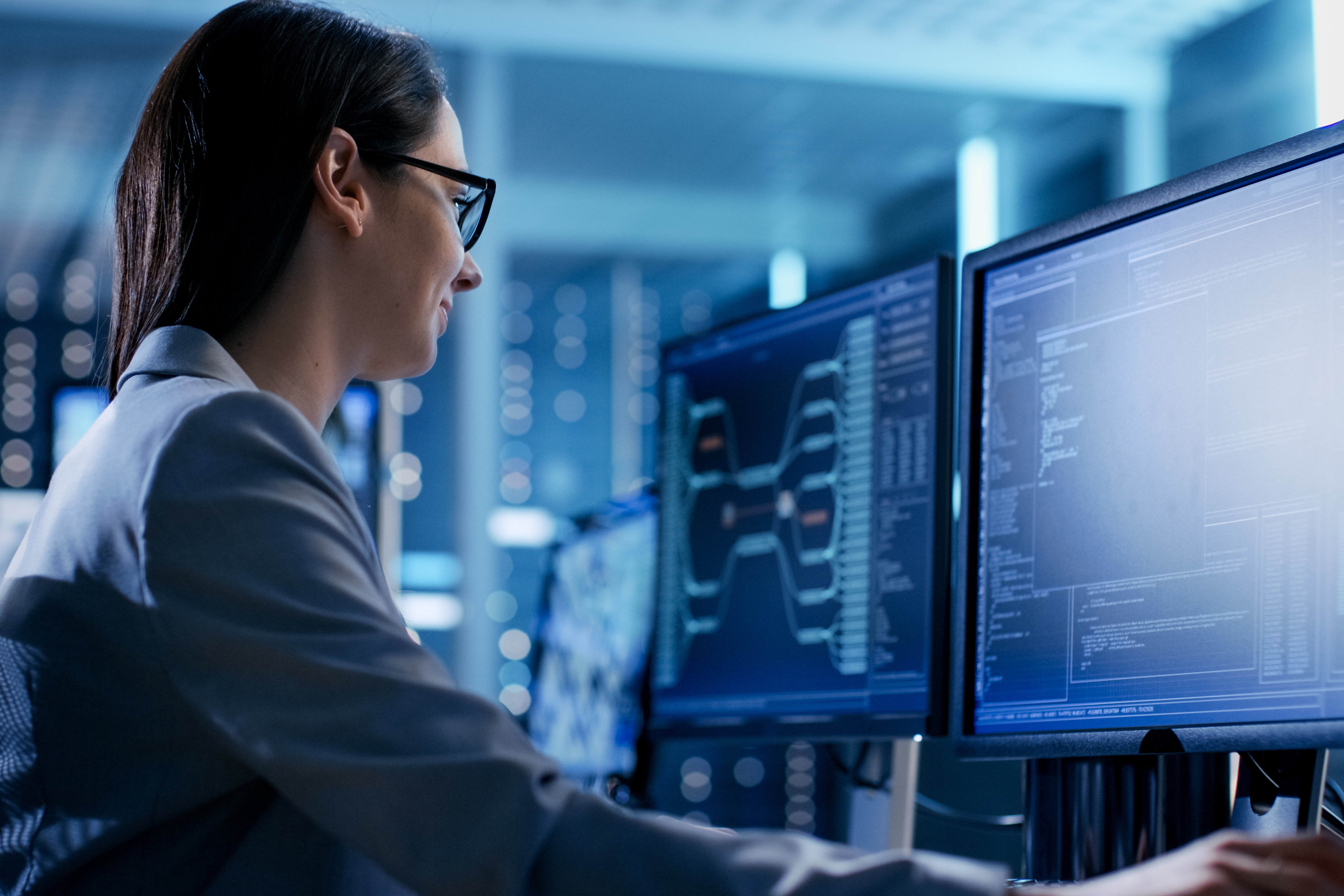 Frau sitzt am Schreibtisch vor einem Computer
