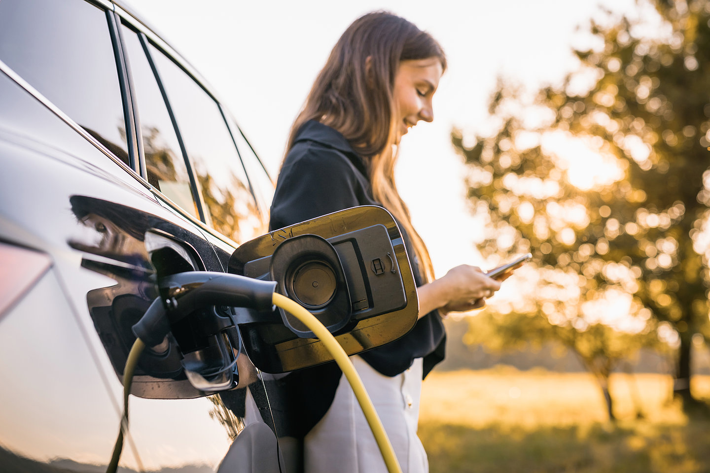 Frau lädet E-Auto
