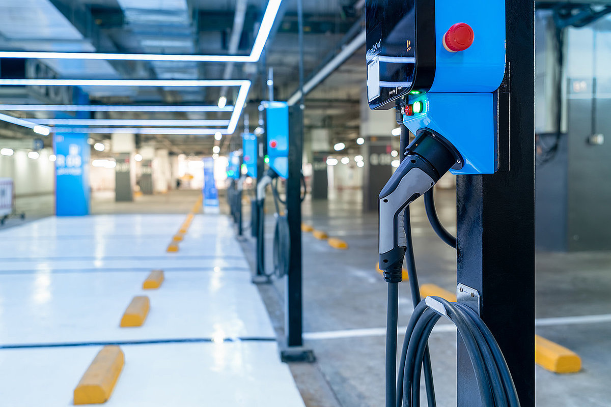 Mehrere blaue Ladesäulen in einer Tiefgarage.