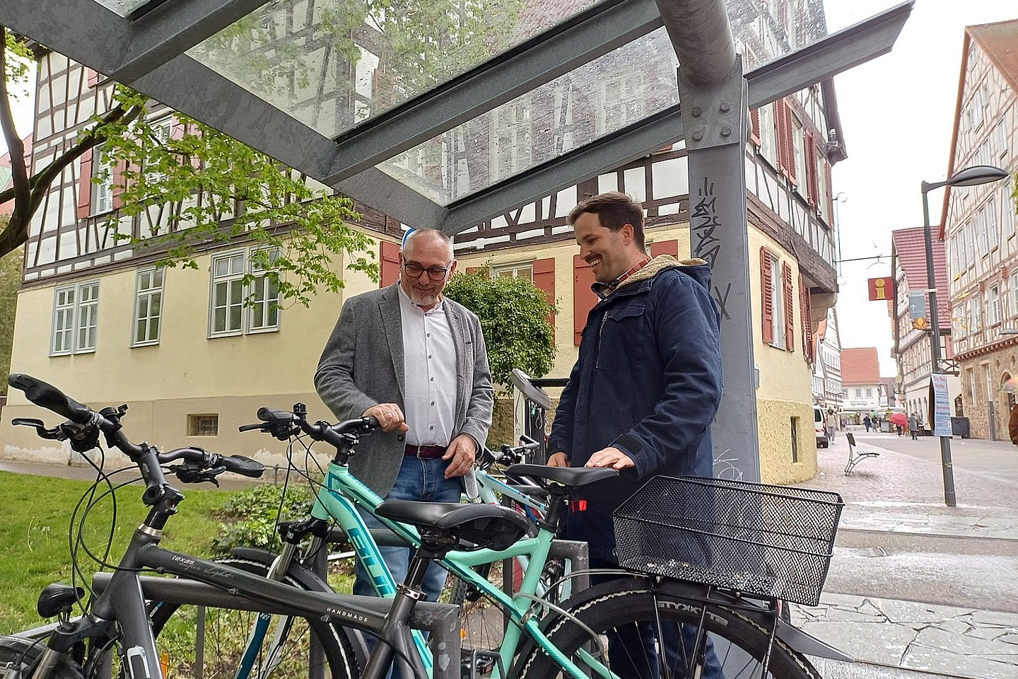zwei Männer stehen an einem Fahrradständer vor einer Fußgängerzone