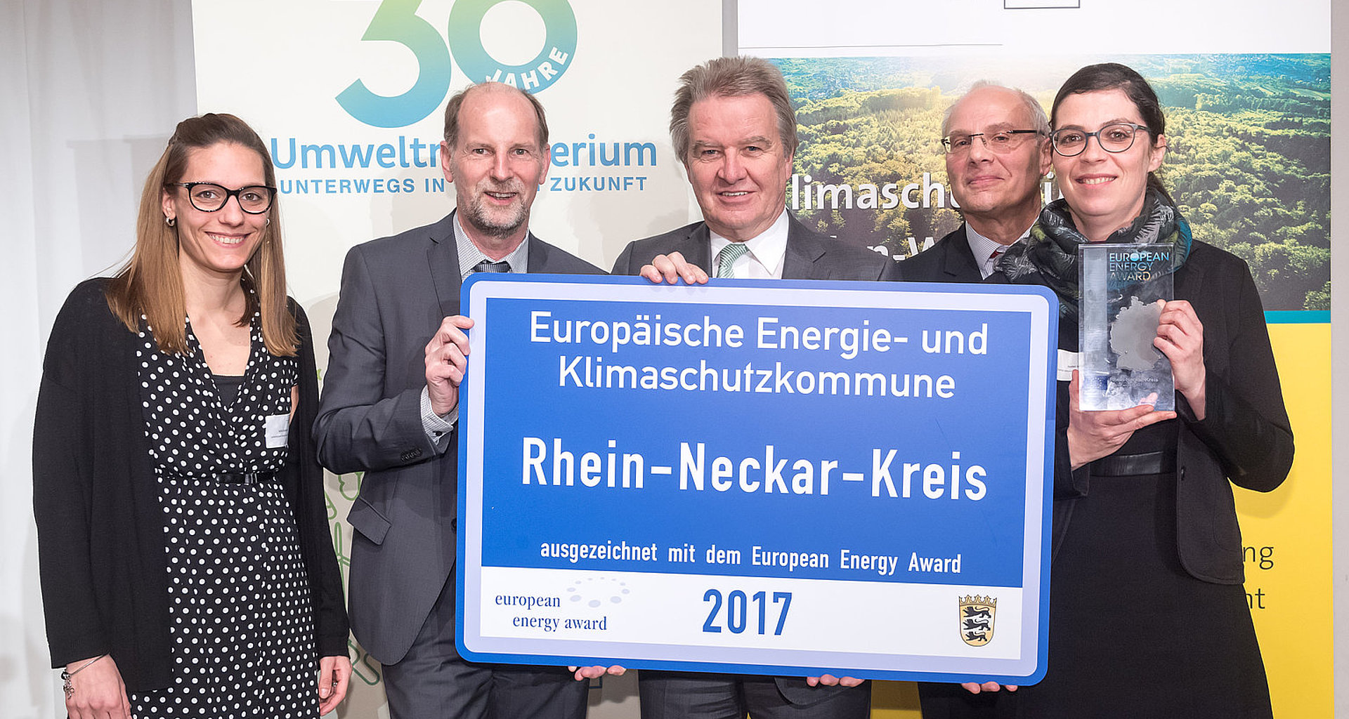 Fünf Menschen halten die Auszeichnung "europäische Klimaschutz- und Energiekommune Rhein-Neckar-Kreis 2017" in den Händen.