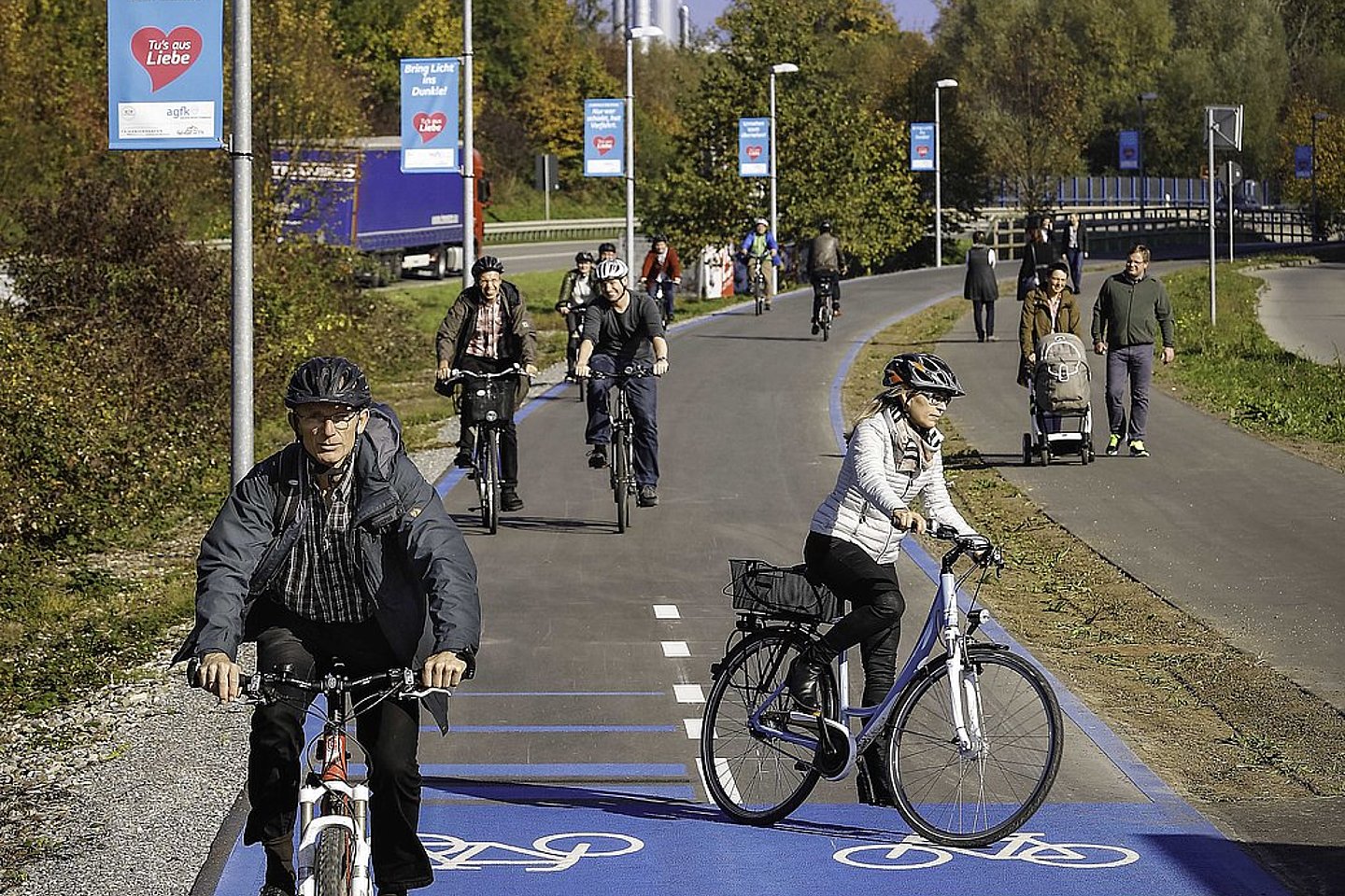 Fahrradfahrende auf Veloring neben separater Straße mit Lkw und extra Fußweg