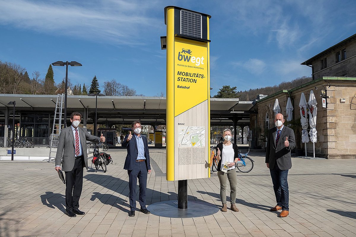 Menschen aus dem Verkehrsministerium stehen vor einer Mobilitätssäule