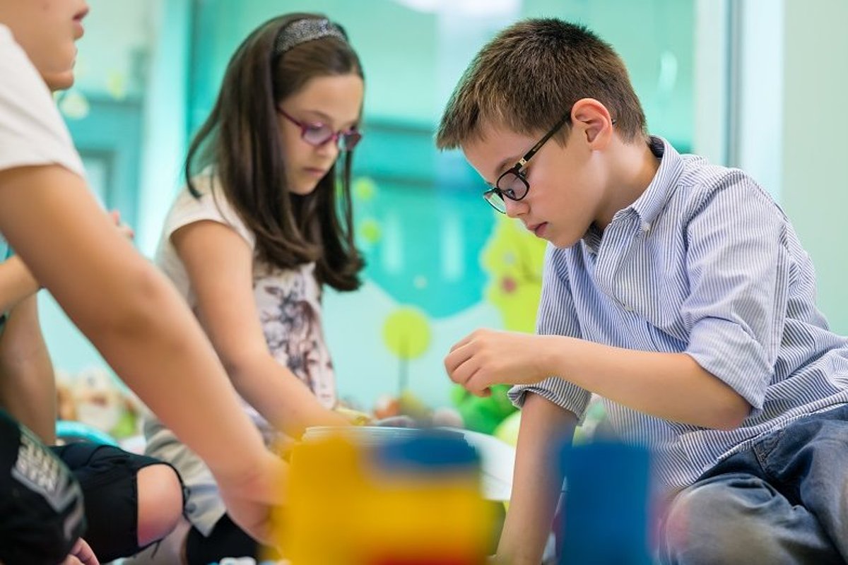 Kindergartenkinder schauen sich interessiert etwas an.