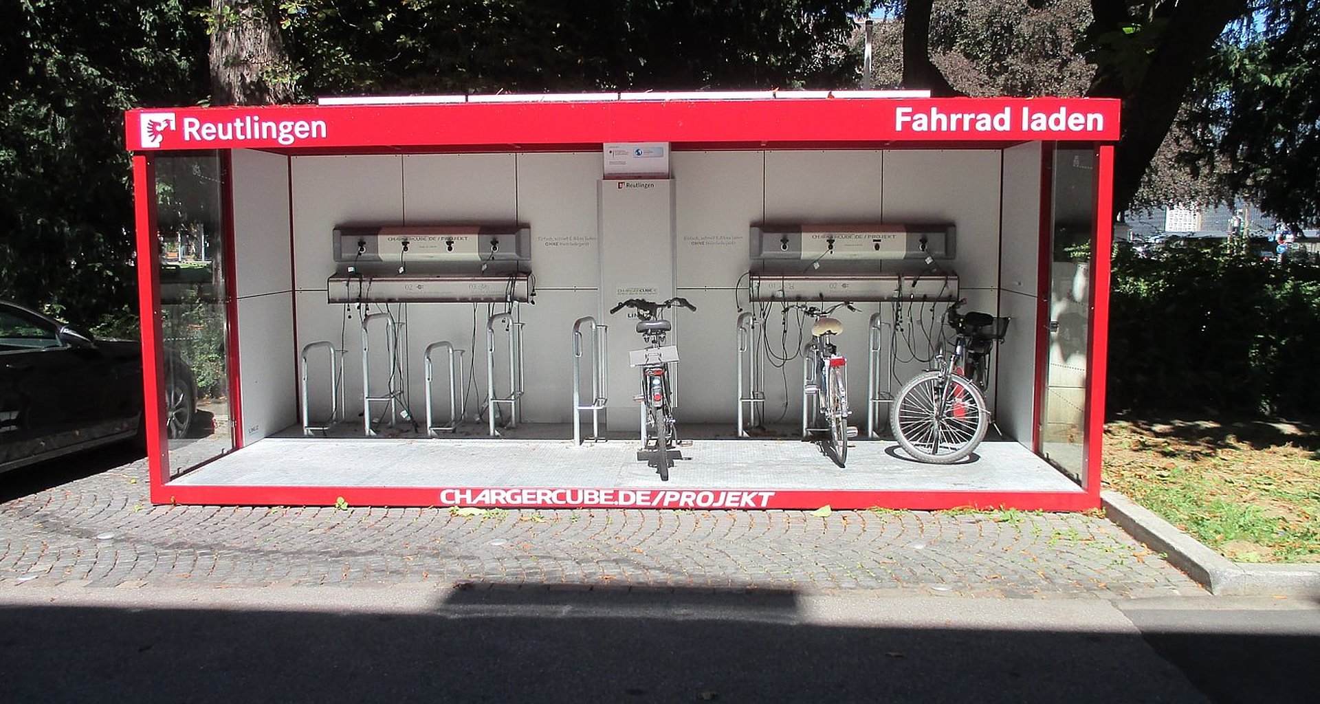 Foto einer überdachten, roten E-Bike Ladestation