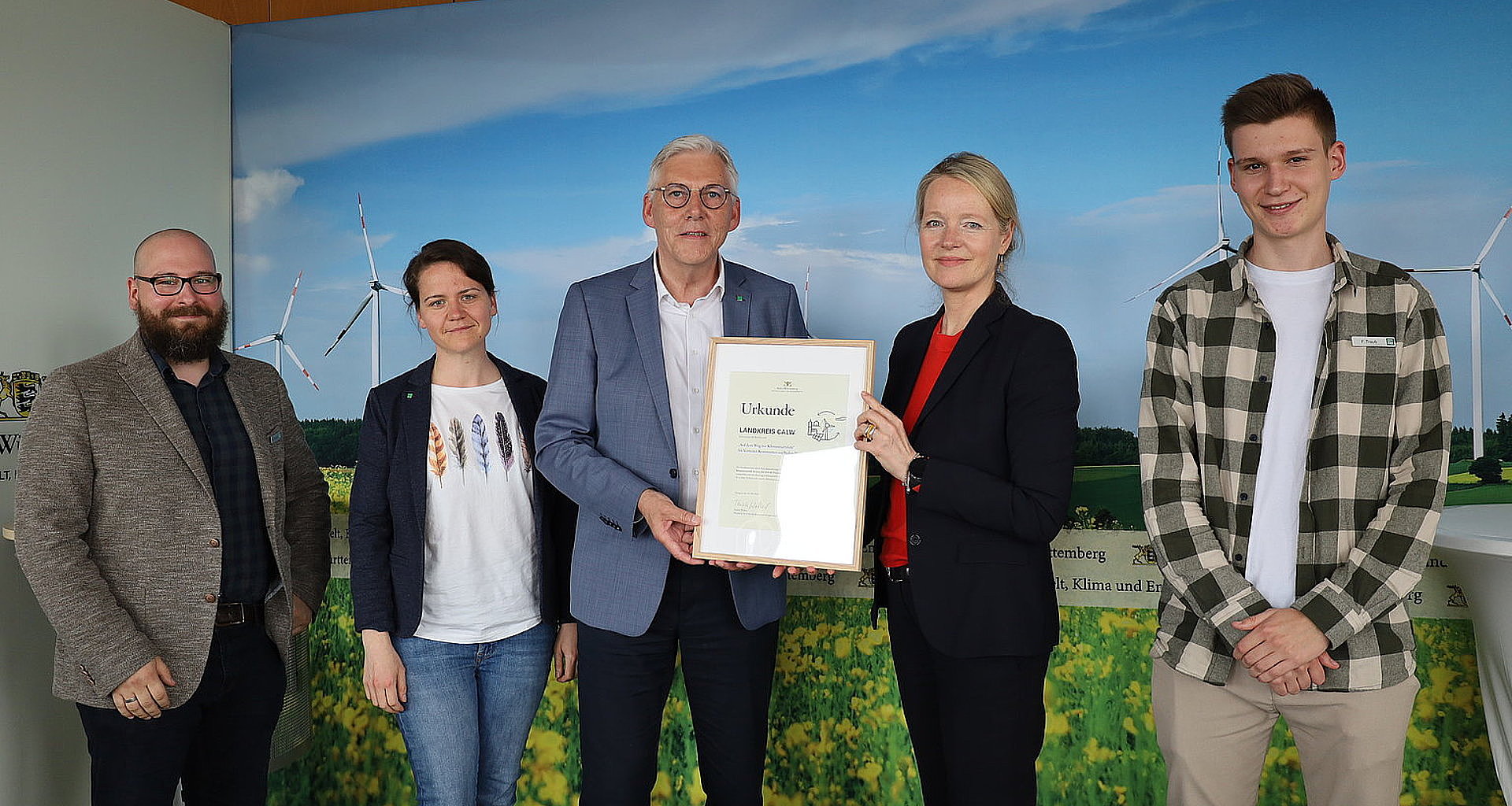 Fünf Menschen stehen nebeneinander bei der Urkundenübergabe Urkundenübergabe an den Landkreis Calw beim Kommunen-Wettbewerb "Auf dem Weg zur Klimaneutralität bis 2035"