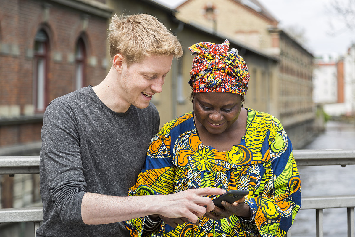 Mann zeigt Frau Mobilitätsinformationen am Handy