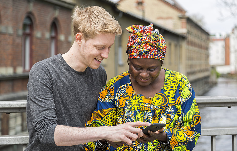 Mann zeigt Frau Mobilitätsinformationen am Handy