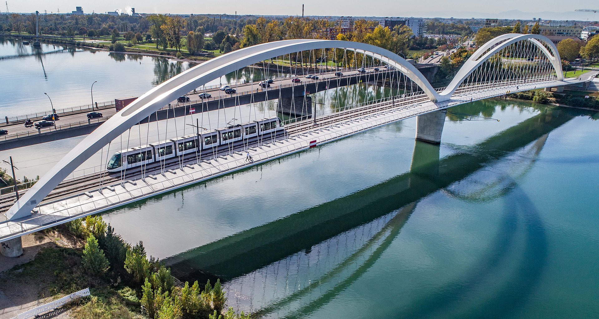 Drohnenaufnahme der Trambrücke in Kehl mit einer Bahn, Autos und Fußgängern