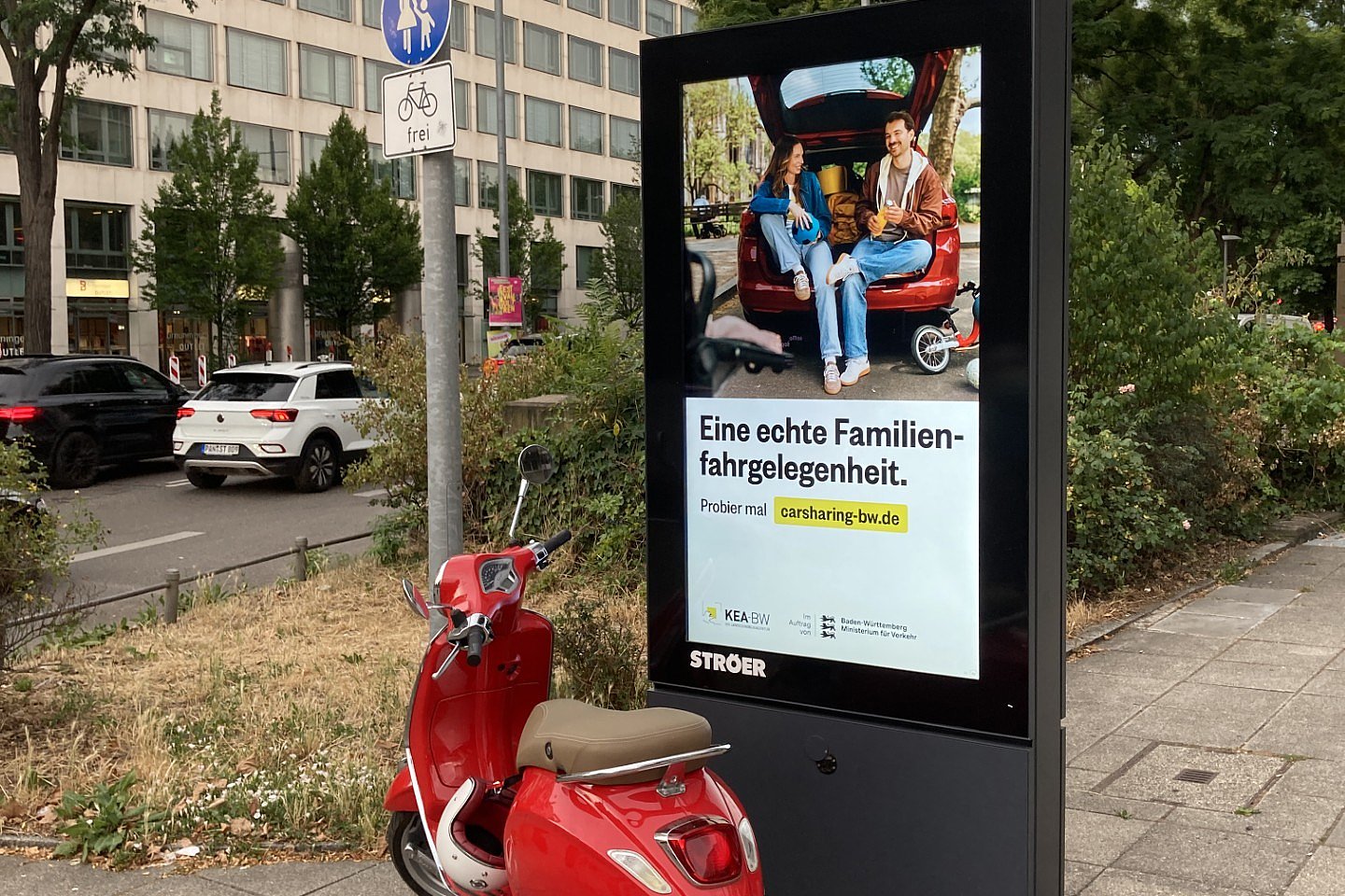 Werbefläche mit Familienmotiv und Carsharing-Auto