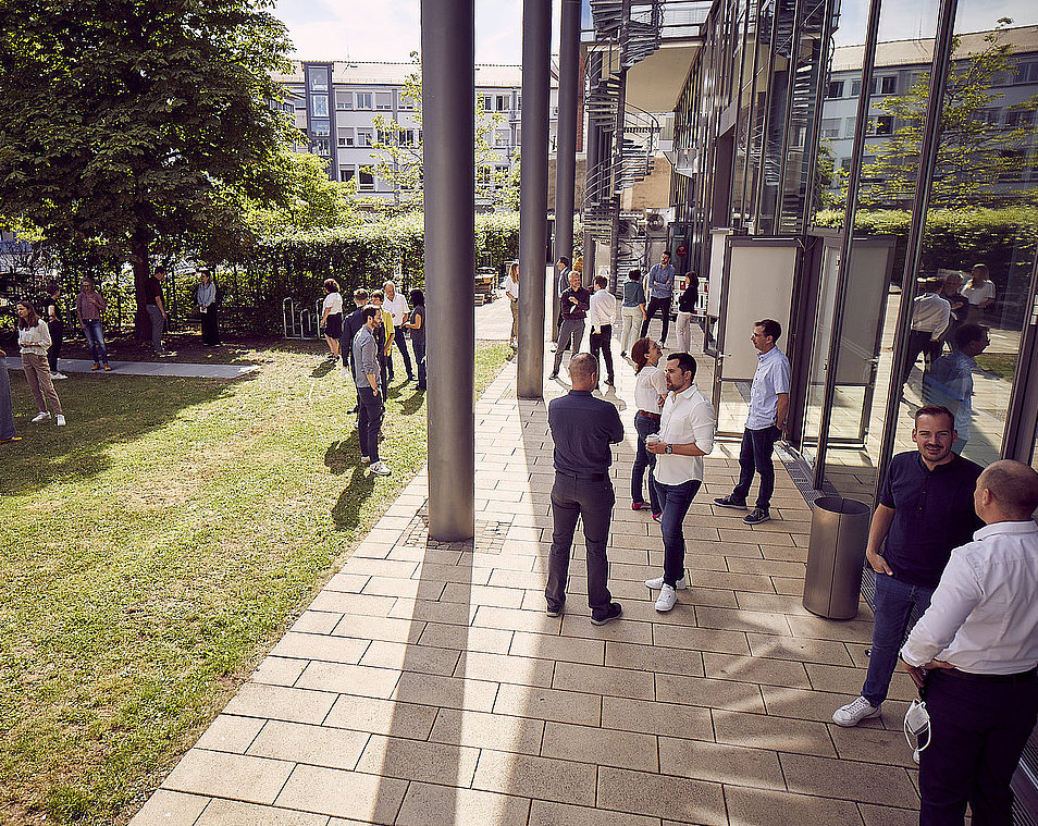 Link zu Stellenausschreibungen. Foto zeigt Mitarbeiter und Mitarbeiterinnen der KEA-BW, die sich draußen unterhalten.