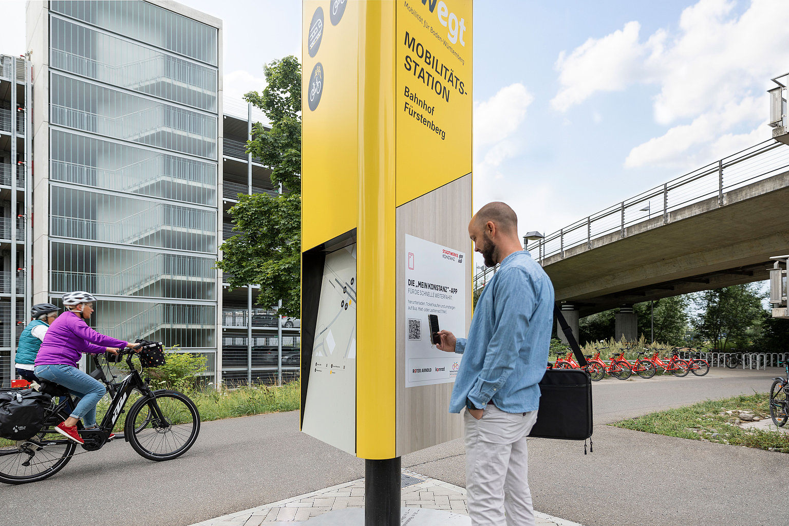 Ein Mann informiert sich an einer Mobilitätssäule