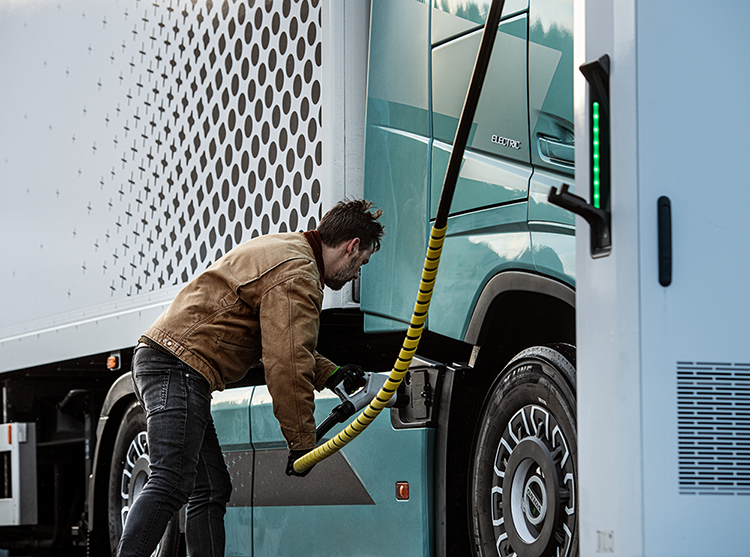 Mann lädt Elektro-Lkw