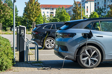 E-Auto auf öffentlichem Parkplatz an Ladesäule angeschlossen