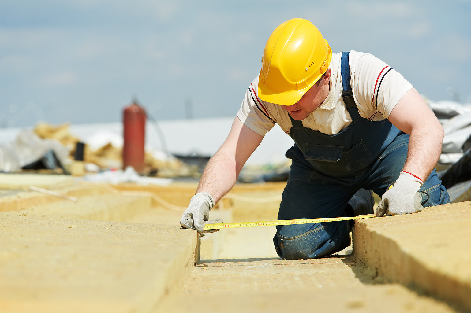 Handwerker, der ein Flachdach dämmt